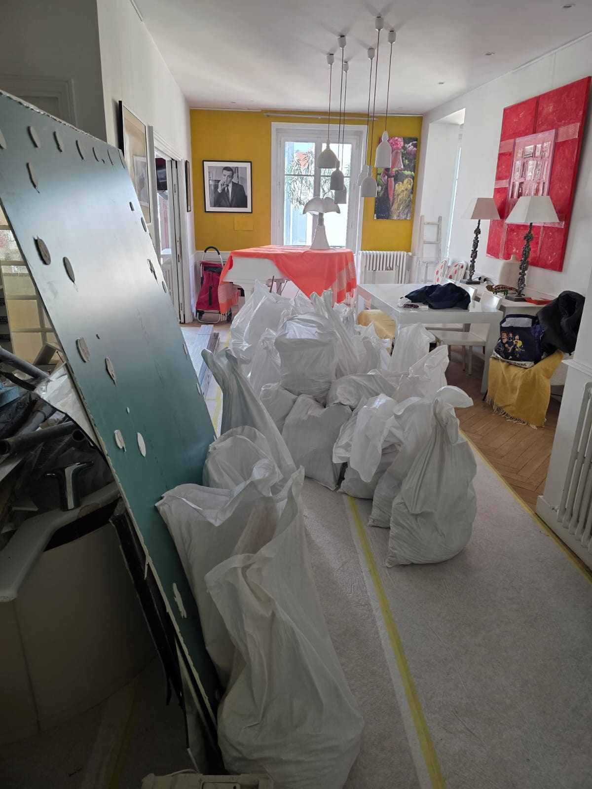Sacs de gravats prêts à l’évacuation, parquet et pièces de vie protégés pendant le chantier