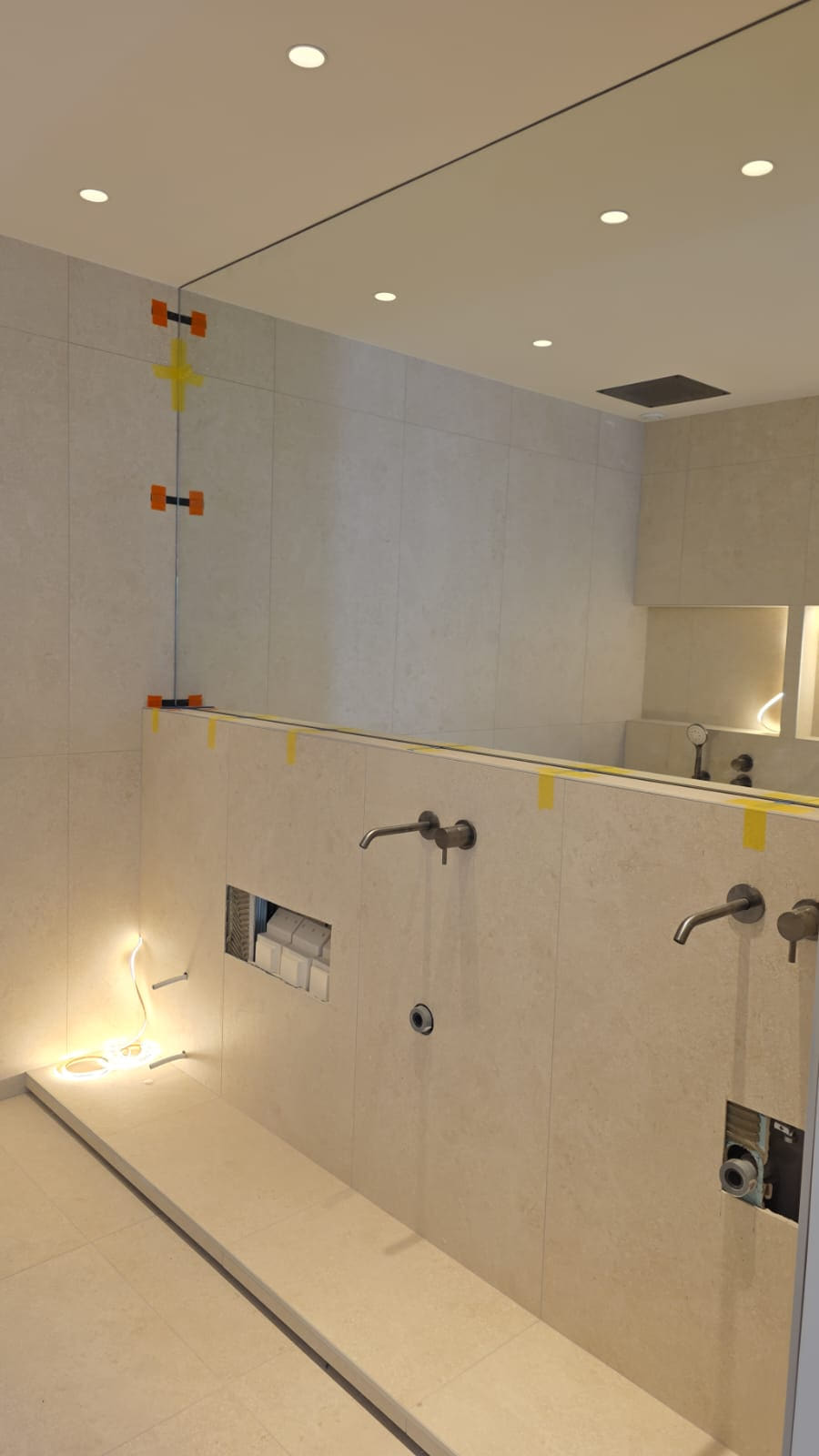 Collage du miroir toute largeur et réglage de la robinetterie encastrée en fin de chantier