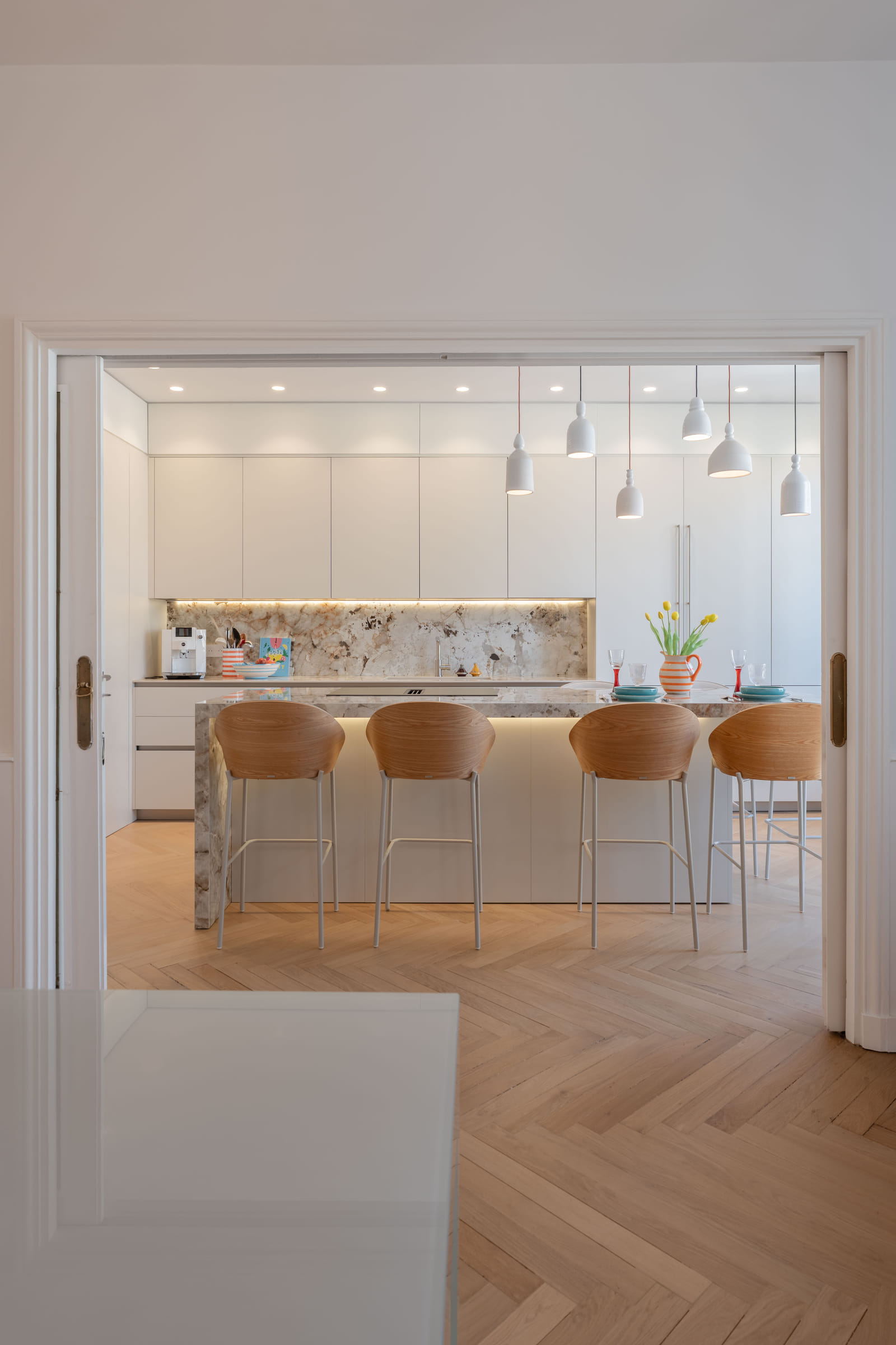 Enfilade de la salle à manger vers la cuisine, cadrée par les portes à double battant d’origine